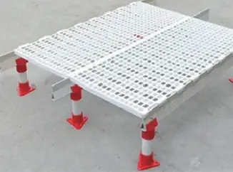 Plastic slat floor panels mounted on adjustable red legs